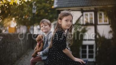 小欧洲男孩和女孩的肖像。 <strong>兄妹</strong>俩坐在一起看镜头.. 一半的木屋。 4K.